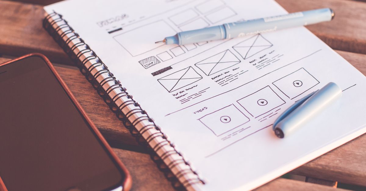 Croquis de wireframe et maquette de site web sur un carnet